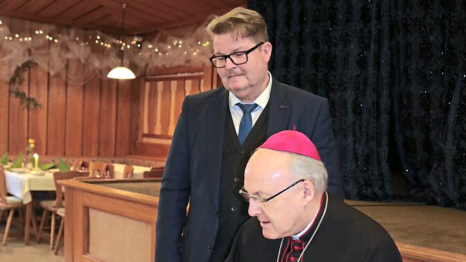 Der Bischof (r.) trägt sich ins Goldene Buch des Marktes Essenbach ein.