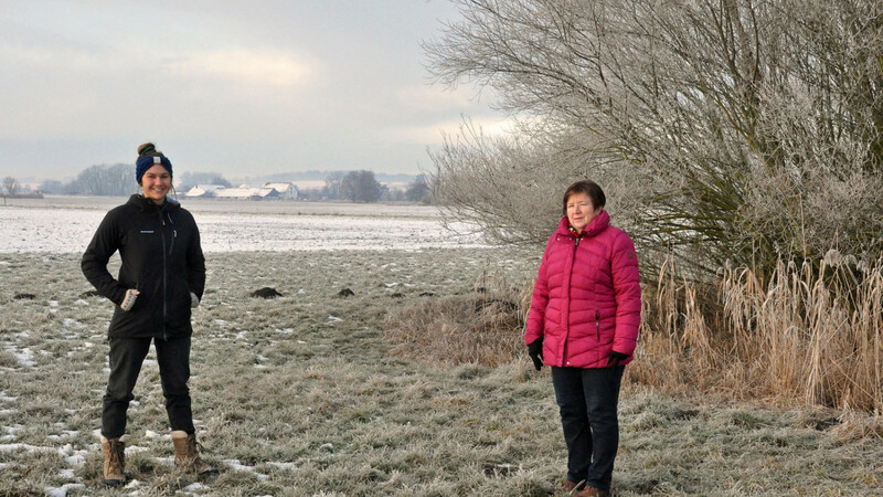 Bürgermeisterin Ida Hirthammer (rechts) mit der Projektmanagerin Lucia Gruber beim Pressegespräch vor dem für die Freischneidung vorgesehenen Bereich. Im Hintergrund ist Appersdorf zu sehen.