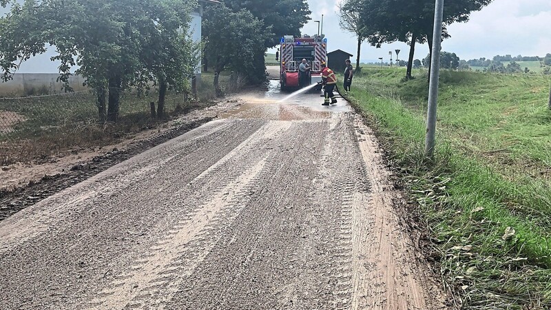 In Unterglaim halfen die Ergoldinger Feuerwehrler ihren Oberglaimer Kollegen, eine Straße vom Schlamm zu säubern.