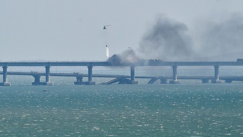 Ein Hubschrauber wirft Wasser ab, um das Feuer auf der Krim-Brücke zu stoppen, die das russische Festland und die Halbinsel Krim über die Straße von Kertsch verbindet.