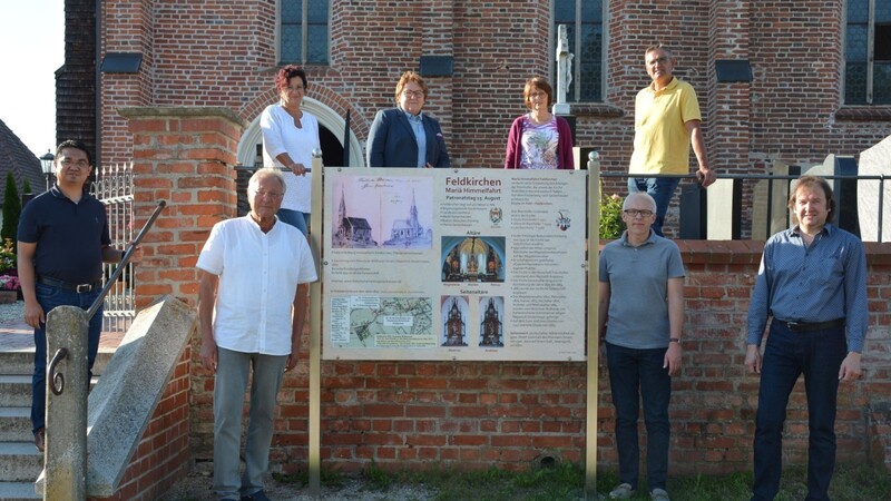 Im Beisein von Pater Altus Jebada, der Kirchenbeauftragten des Pfarrverbandes Sabine Fries, der Kirchenverwaltung Feldkirchen unter Leitung von Franz Strasser hat Heimatforscher Peter Käser (links von der Tafel) die Geschichts-Schautafel seiner Bestimmung übergeben.