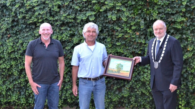 Bürgermeister Thomas Einwang verabschiedet seinen Kämmerer Hans Ramsauer im Beisein von Altbürgermeister Hans Rambold (links) mit einem Ölgemälde von Lenz Rott mit Blick von Ella auf sein Heimathaus in Steeg.