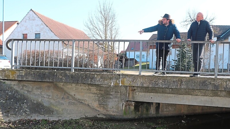 Bürgermeister Christian Kiendl (rechts) und Hans Haubner vom Bauamt begutachten die Brücke über den Allersdorfer Bach in der Loiblstraße. Diese hat Mängel und muss saniert werden.