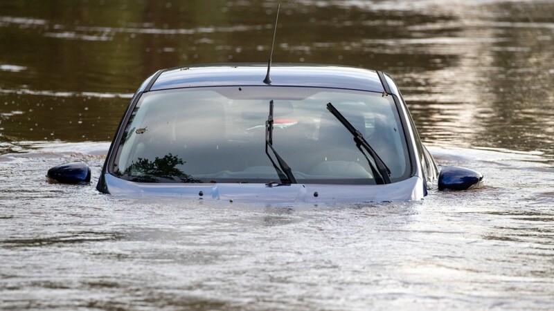 Ein Auto steht auf einem Parkplatz im Hochwasser, nachdem die Aisch über die Ufer getreten war.