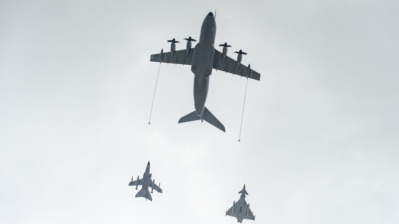 Ein Airbus A400M Transportflugzeug (o) fliegt neben Militärflugzeugen über den Fliegerhorst Wunstorf.