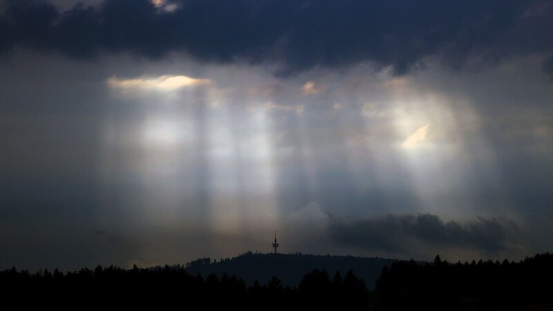 Sonnenstrahlen dringen durch Wolkenlücken.