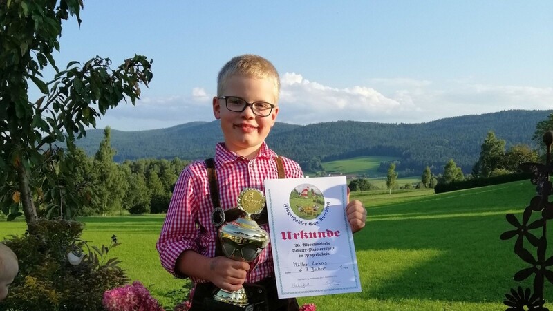 Stolz zeigt Lucas Müller zu Hause seinen Pokal und seine Urkunde her.