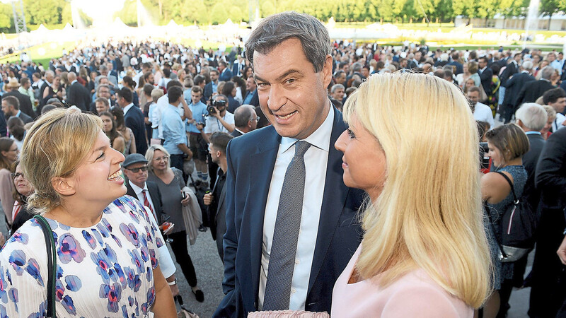 Markus Söder (CSU, M), Ministerpräsident von Bayern, und seine Frau Karin (r) stehen mit Katharina Schulze, eine der Vorsitzenden der Grünen-Fraktion im bayerischen Landtag, beim Sommerempfang des bayerischen Landtags auf der Terrasse von Schloss Schleißheim.