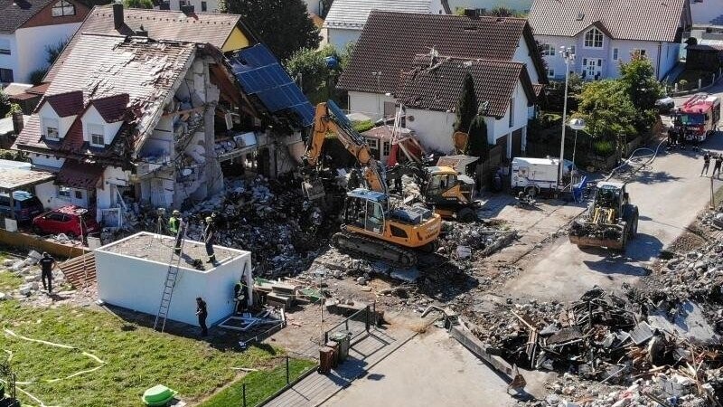 Zwei Bagger und ein Radlader sind bei Bergungsarbeiten an den Überresten des Hauses im Einsatz.