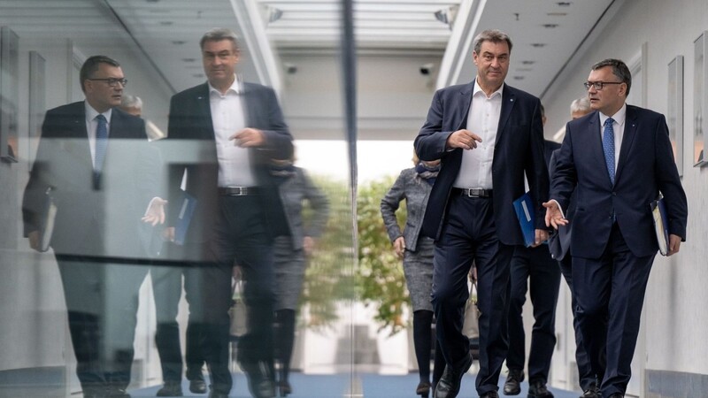 Markus Söder (l, Ministerpräsident von Bayern, und Florian Herrmann, (beide CSU), Leiter der Staatskanzlei und Staatsminister für Bundes- und Europaangelegenheiten und Medien, gehen zusammen durch die bayerischen Staatskanzlei zur Kabinettssitzung.