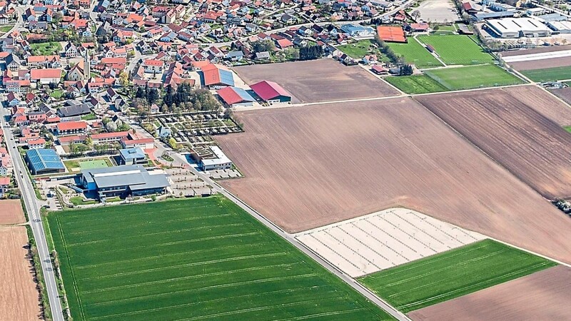 Auf dem Luftbild von Essenbach zeichnet sich der Bauplatz für das neue Landratsamt in der rechten Bildhälfte noch als graubraune Ackerfläche ab. Am linken Bildrand ist die B 15 zu sehen, rechts davon die Eskara und im Anschluss die Musikschule. Der Eskara-Parkplatz (helle Fläche) wird dem Landratsamt auch zur Verfügung stehen.