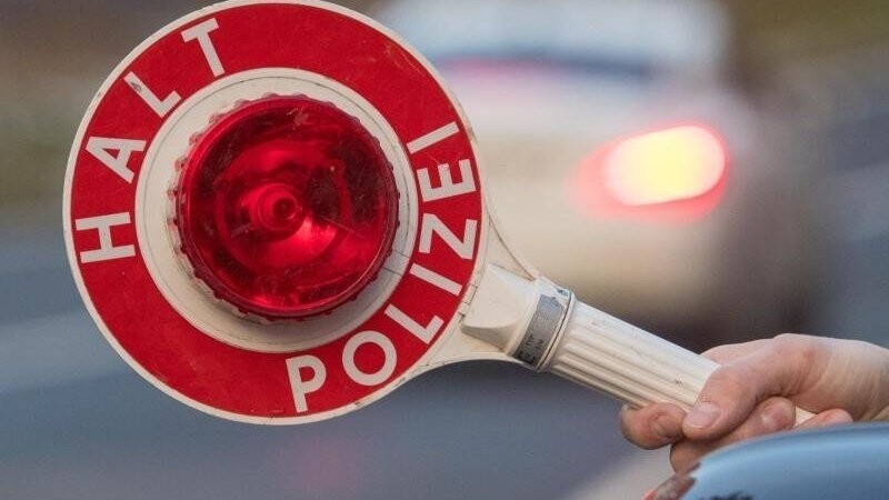 Eine Polizeikelle wird bei einer Polizeikontrolle aus einem Fahrzeug der Polizei gehalten. Foto: Armin Weigel/Archiv