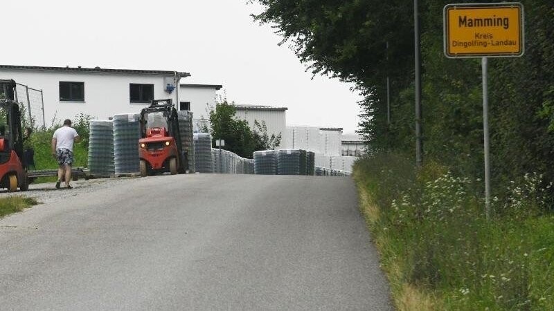 Arbeiter errichten eine Zaun um die Wohngebäude eines Betriebes in Mamming.