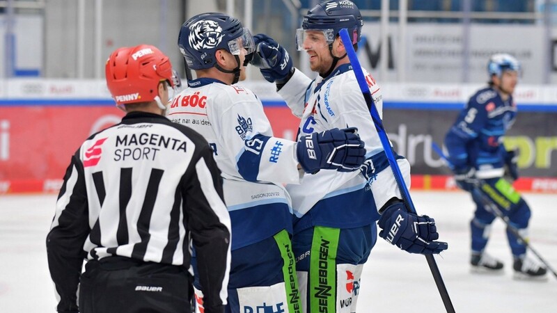 Tim Brunnhuber (M.) von den Straubing Tigers beglückwünscht seinen Kapitän Sandro Schönberger vor den Augen des Schiedsrichters zu dessen Treffer zum 1:0.