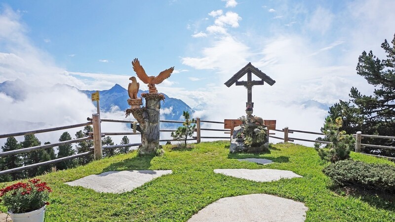 Auf der Kalbenalm: Der Himmel reißt auf und über den Nebelwolken erhebt sich die gegenüberliegende Bergkette.