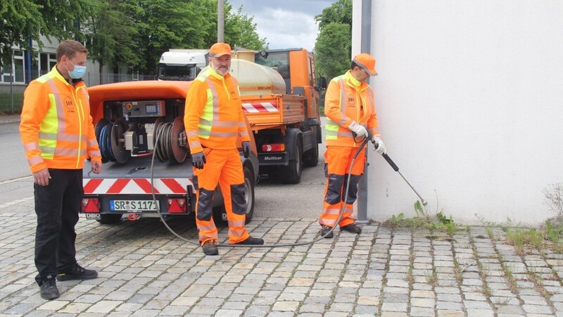 Sergej Gusselmann (rechts) und Fahrer Mirko Cechura (Mitte) demonstrieren mit Vorarbeiter Roman Pflaumer von der SER die unterschiedlichen Einsatzmöglichkeiten des Heißwassergeräts.