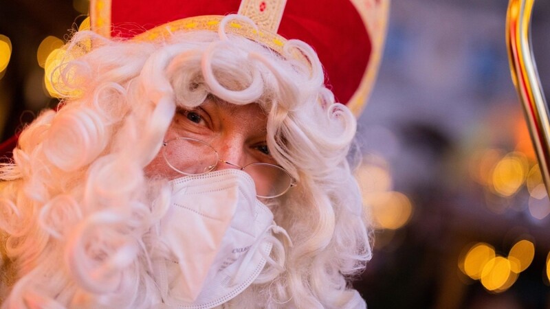 Stefan Dößereck, Nikolaus- und Weihnachtsmanndarsteller, trägt eine FFP2-Maske auf dem Weihnachtsmarkt "Nikolausdorf" auf dem Rudolfplatz.
