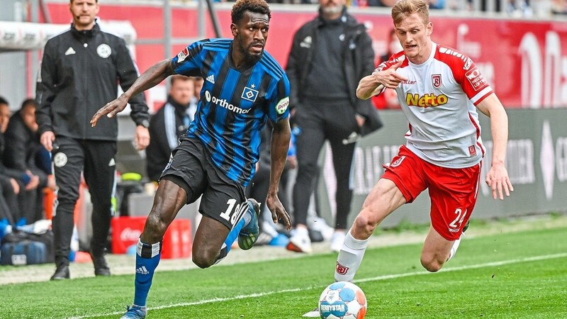 Defensive Arbei zu verrichten, ist für Jahn Abwehrspieler Scott Kennedy - hier im Laufduell mit Hamburgs Stürmer Bakery Jatta (l.) - mehr Vergnügen als Arbeit.