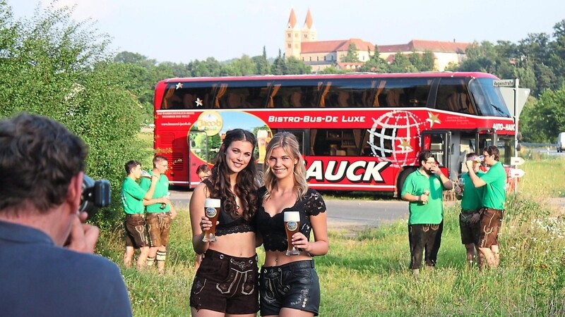 Vor der Kulisse des Reichenbacher Klosterberges setzt Fotograf Clemens Mayer die Models Eva Loy und Theresa Sadlo samt Weißbier in Szene. Im Hintergrund die Mitglieder des Burschenvereins als Statisten.