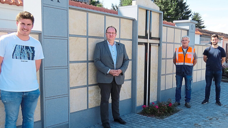 Andreas Pielmeier von der Stadtverwaltung, Bürgermeister Herbert Lichtinger, Stefan Hierl vom Bauhof und Michael Müller von der Stadtverwaltung (v. l.)vor der neu errichteten Urnenwand im alten Teil des Friedhofs.