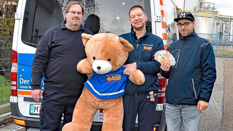 Manuel Förster (v. r.) bei der Spendenübergabe an Andreas Kotter und Björn Feldmann vom ASB-Wünschewagen München-Oberbayern.