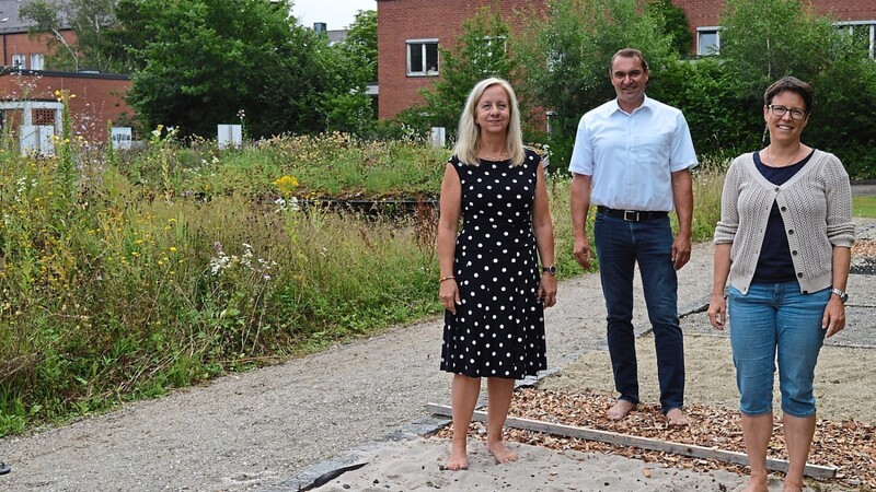 Dr. Hannelore Omari, Bürgermeister Alfred Holzner und Umweltreferentin Veronika Oberpriller testen den Barfußpfad an der Station bei der Lebenshilfe, der heuer erst erneuert worden ist.