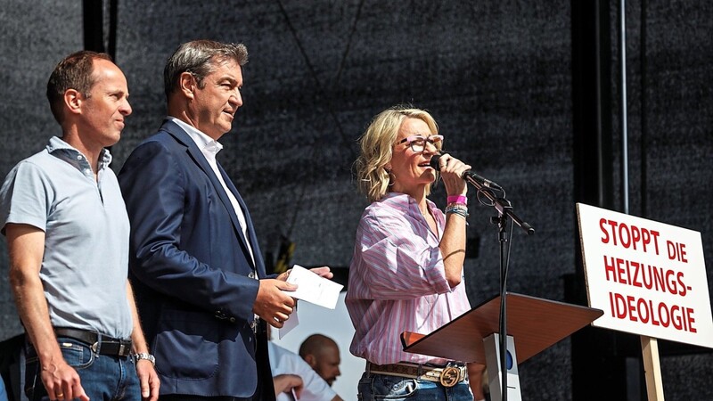 Markus Söder (Mitte) steht mit dem Initiator der "Heizungsideologie"-Demo,Optiker Franz Widmann, und Kabarettistin Monika Gruber auf der Bühne in Erding.Gruber hat die Demonstration mitorganisiert. Sie wird gefeiert, während es für den Ministerpräsidenten eher wenig Zuspruch gibt.