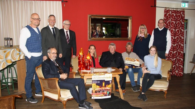 Josef Stelzl (5.v.r.) stellte das Konzept für den Christkindlmarkt mit Annemarie Schneider (3.v.r.), Mitarbeitern des Stadtmarketings, Petra Müller (6.v.r.), Thomas Bräuherr (4.v.r.) und Matthias Reisinger (r.), Johannes Zeindlmeier (l.) und Peter Markgraf (sitzend, l.) von der Werbegemeinschaft sowie OB Markus Pannermayr (2.v.l.) und Berufsmäßigem Stadtrat Alois Lermer (4.v.l.) vor. Katharina Prinz (sitzend, r.) ist das Christkind. Auf dem Tisch stehen die Kerzen für die Geschäfte.