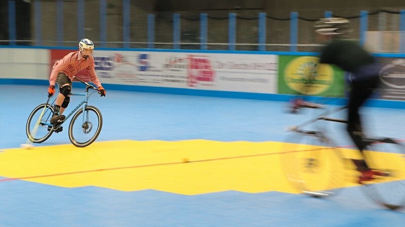 In voller Fahrt: Beginn eines Bikepolo-Spiels mit dem Ball im Mittelpunkt der Spielfläche. Die Spieler preschen aufeinander zu, um ihn zu bekommen.