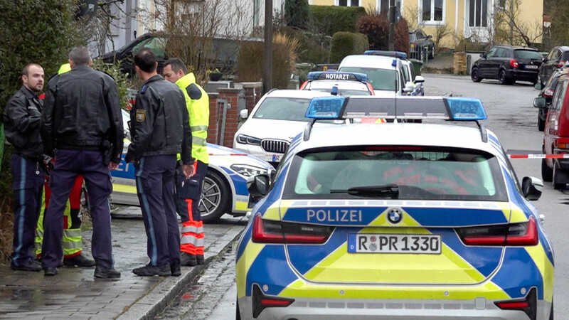 Polizei und Notarzt stehen vor einem Haus. Ein 52 Jahre alter Mann soll eine Seniorin getötet und ihre Enkelin verletzt haben. Die Polizei nahm den Tatverdächtigen in unmittelbarer Nähe zum Tatort fest.