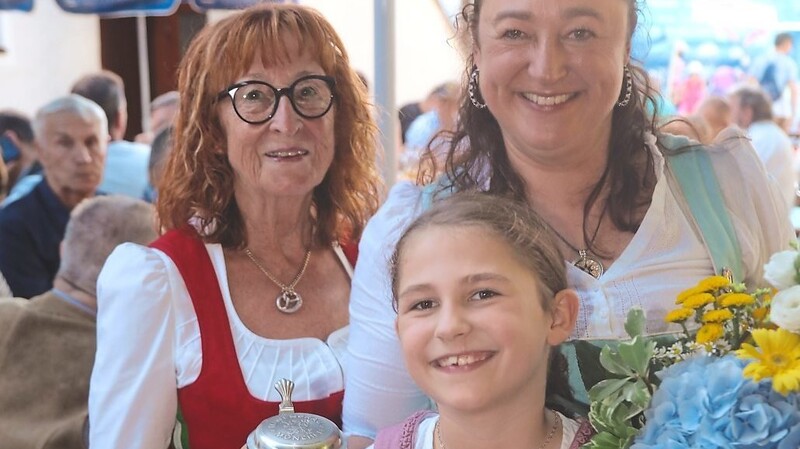 Seniorwirtin Christl Kuttenlochner, Wirtin Andrea Kuttenlochner, Enkelin Christina mit Ehrenurkunde und limitiertem Maßbierkrug.