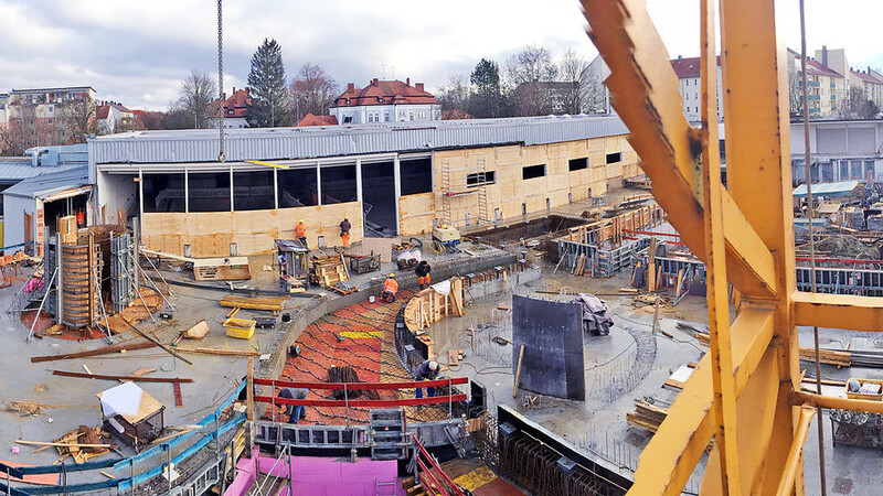 Auf der Hallenbad-Baustelle wird mit Hochdruck gearbeitet: links im Vordergrund der neue Anbau, im Hintergrund das alte Hallenbad-Gebäude, das gerade mit Holzplatten winterfest gemacht wird. Solange die Witterung es erlaubt, sind die Handwerker vor Ort.