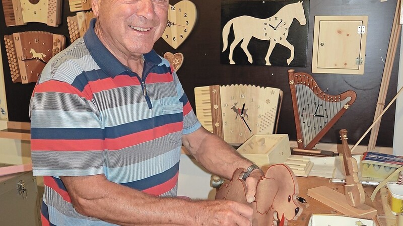 Nach der Vorarbeit in der Schreinerwerkstatt baut Franz Binder in seinem Bastelraum die Uhrwerke in die Holzformen ein.