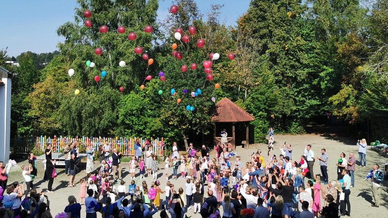 Die Abc-Schützen lassen zum Abschluss ihres ersten Schultages bunte Luftballons fliegen.