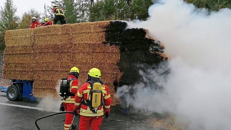 Mit Einreißhaken und Mistgabeln warfen die Feuerwehrkräfte in der Anfangsphase die brennenden Strohballen auf die Straße, um sie einzeln ablöschen zu können.