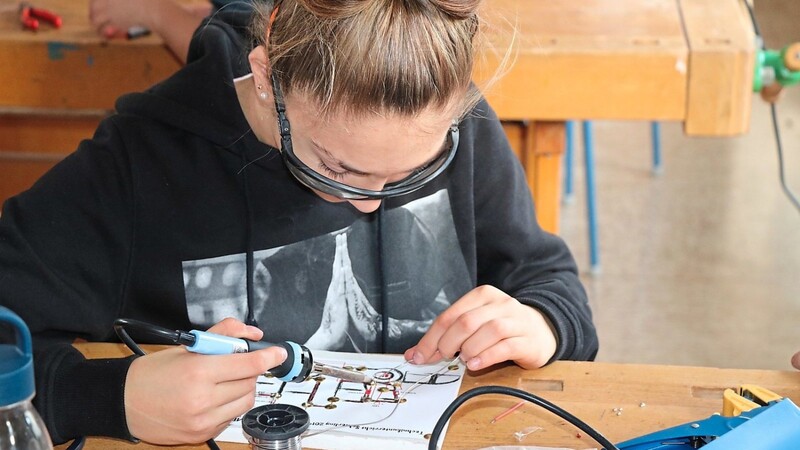 Eine Schülerin lötet. An der Langquaider Mittelschule kommen die Jugendlichen frühzeitig mit Betrieben in Kontakt.