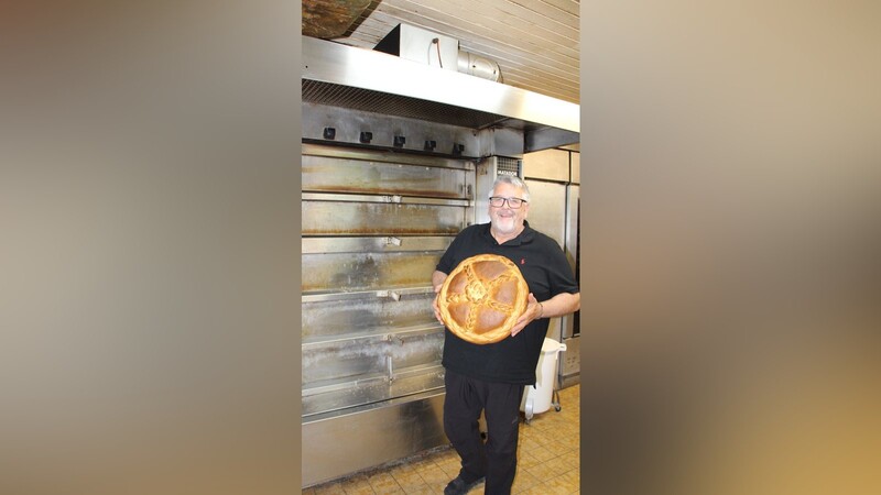 Johann Kroul steht mit einem Übungsstück eines seiner Auszubildenden in der Plendl-Backstube in der Simon-Höller-Straße.