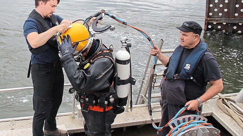 Circa 26 Kilo an Blei trägt der Taucher verteilt am Körper, unter anderem an den den Füßen und im Helm. So sinkt er nach unten.