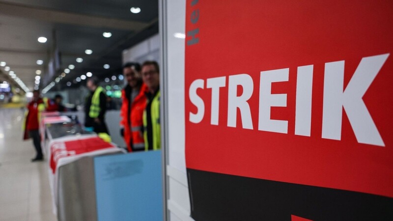 Ein Streikposten steht am Flughafen Köln/Bonn im Terminal.