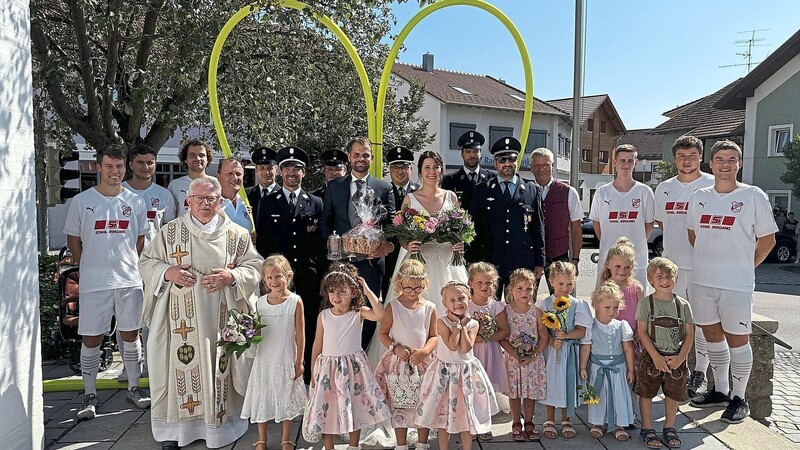 Vor der Pfarrkirche wartete nach der kirchlichen Zeremonie bereits eine stattliche Anzahl von Kindern, Fußballern und Feuerwehrleuten, welche das Brautpaar mit einem Schlauchherz empfingen.