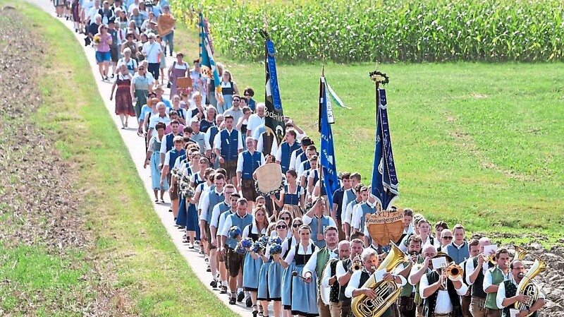 Der Festzug schlängelte sich hinauf zum Open-Air-Gottesdienst auf der Lohrwiese am Ortsausgang von Haunzenbergersöll.