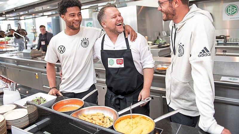 Hautnah an den Stars: Anton Schmaus mit Serge Gnabry (l.) und Jonas Hector (r.) in der Küche.