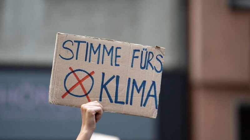 Eine Teilnehmerin hält auf der Fridays for Future-Demonstration ein Protestplakat in den Händen.