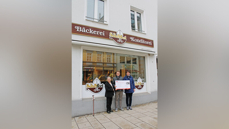 Irmgard Bräu (l.) nimmt mit großer Freude dankbar den Spendenscheck über 13 500 Euro von Junior-Chef Michael Schifferl und Filialleiterin Elke Liebl vor der "Gutes von gestern"-Filiale in der Bahnhofstraße entgegen.