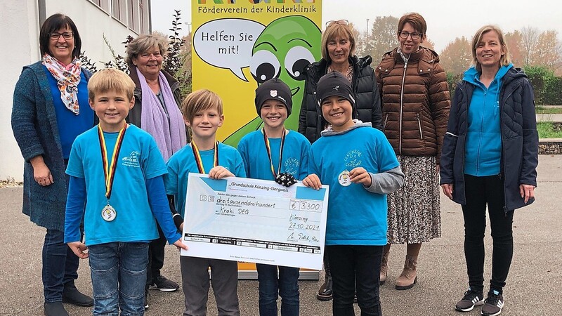 Die fleißigsten Läufer (v.l.) Matthias Problst, Tobias Schönhofer, Moritz Felixberger und Paul Werner dürfen im Beisein von (l.) Rektorin Ulrike Eckl und den Lehrkräften (v.r.) Christine Schiermeier, Andrea Seidl und Birgit Magg den Spendenscheck an die Kraki-Vorsitzende Hela Schandelmaier überreichen.