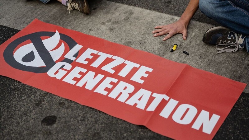 Ein Aktivist der Gruppe "Letzte Generation" blockiert eine Kreuzung.