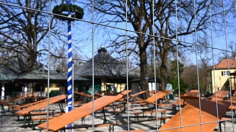 Ein Gitterzaun steht vor den Bierbänken und -tischen am Biergarten am Seehaus im Englischen Garten.