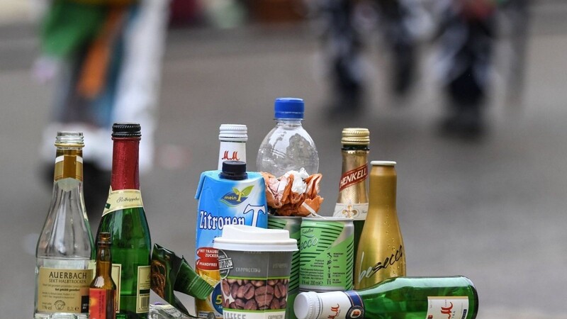 Leere Flaschen diverser alkoholischer Getränke stehen auf einer Mauer.