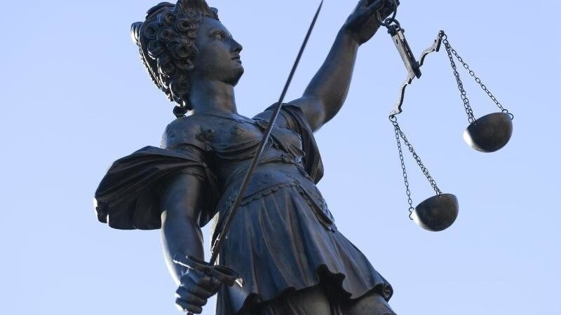 Eine Statue der Justitia steht unter freiem Himmel.