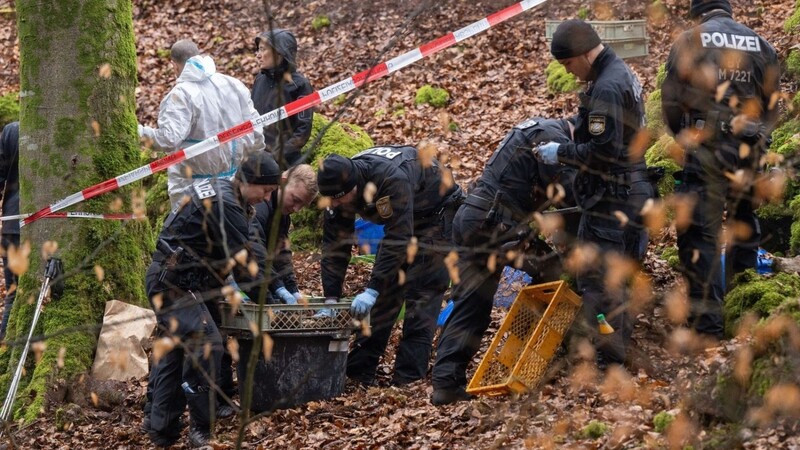 Poizisten suchen ein Gebiet im Wald ab, an dem zuvor menschliche Knochen gefunden worden sind.